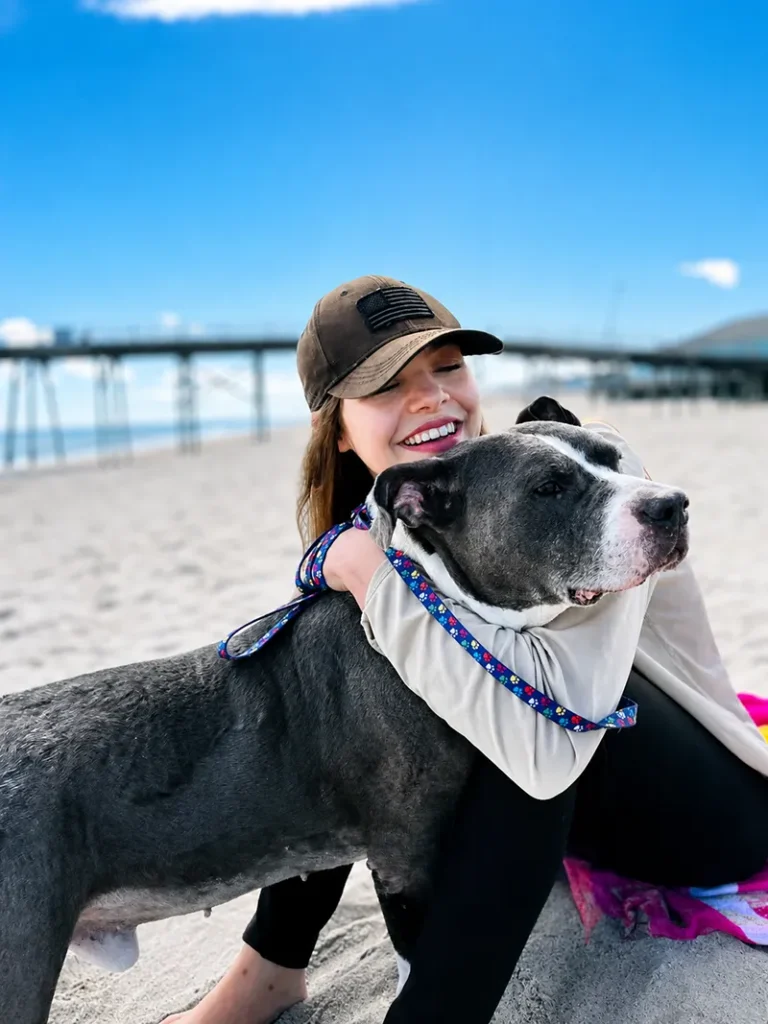image of a CARA dog and a woman on the beach